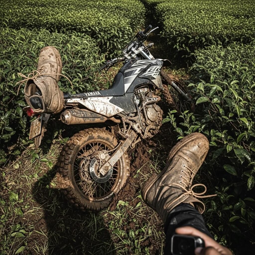 Muddy bike and boots in a tea plantation.